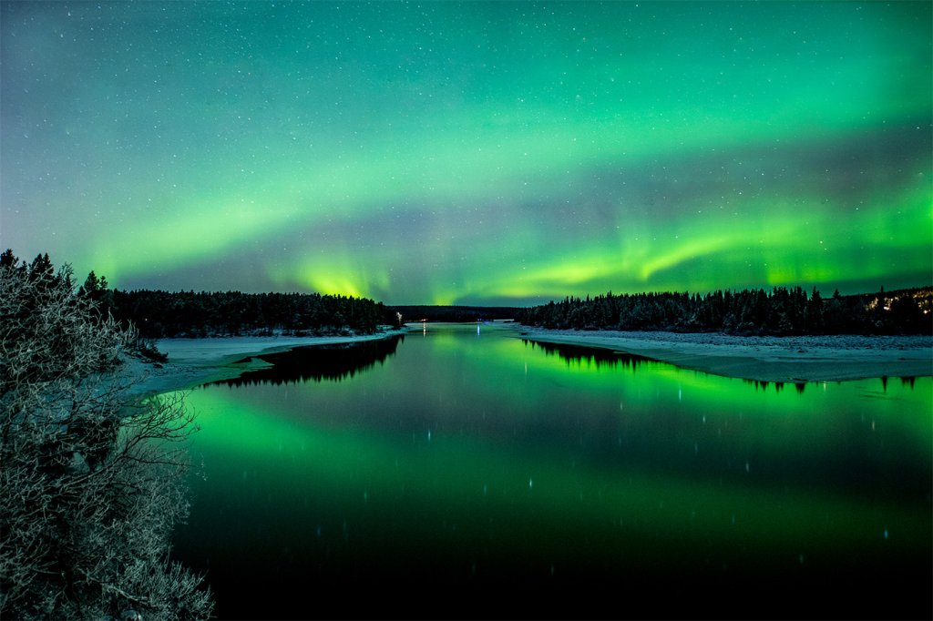 northern lights over torne river icehotel sweden