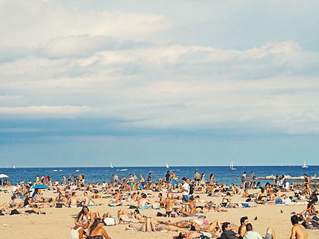 Crowded Barcelona beach Unsplash